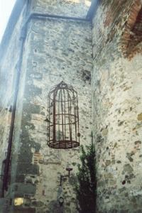 Una antica gabbia esposta all' entrata del castello.