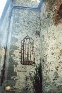 Una antica gabbia esposta all' entrata del castello.